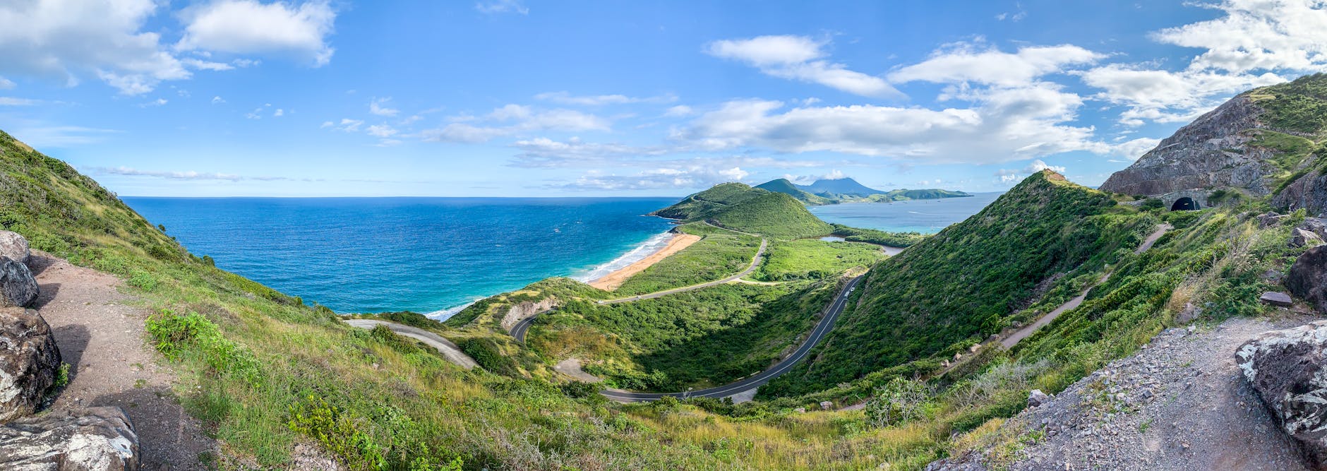 green grass field near blue sea under blue sky